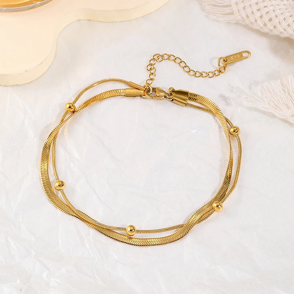 Tornozeleira Dupla com Banho Dourado em Aço Inoxidável – Elegância e Proteção para Seus Momentos Especiais