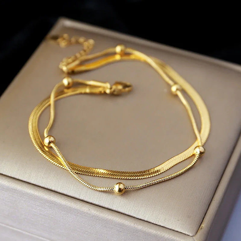Tornozeleira Dupla com Banho Dourado em Aço Inoxidável – Elegância e Proteção para Seus Momentos Especiais